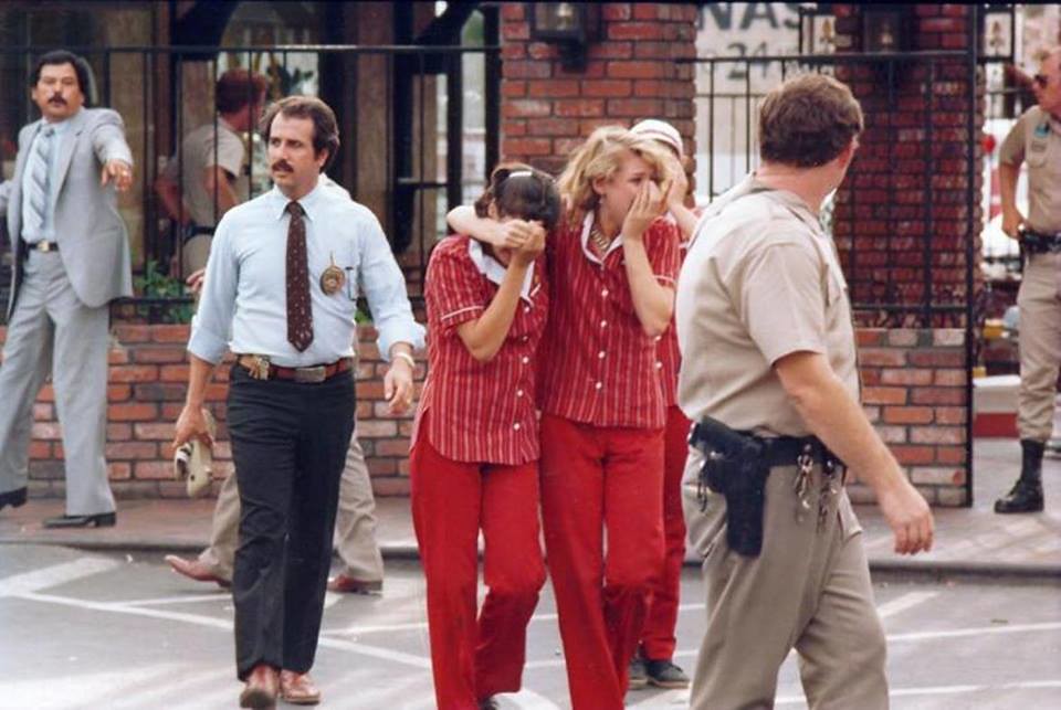 San Ysidro Massacre, 1984. Two employees comfort each other under police escort, as they leave a McDonalds where James Huberty shot and killed several.