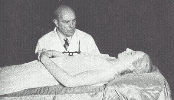 Eva Perón's embalmed corpse is inspected by Dr. Pedro Ara.